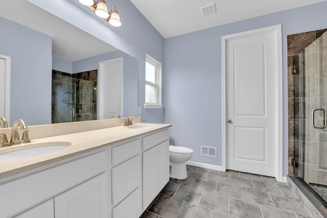 bathroom featuring toilet, vanity, and a shower with door