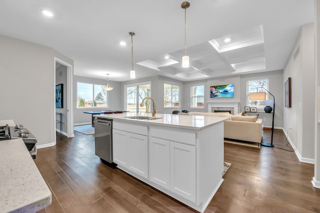 kitchen featuring an island with sink, white cabinetry, sink, and light stone counters