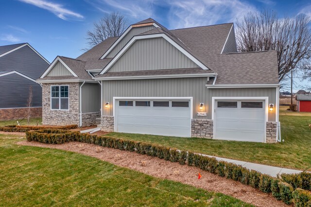 craftsman-style house featuring a garage and a front lawn