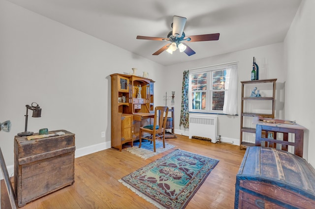 home office featuring ceiling fan, wood-type flooring, and radiator heating unit