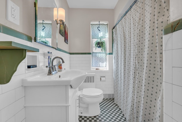 bathroom with a shower with curtain, vanity, tile walls, and toilet