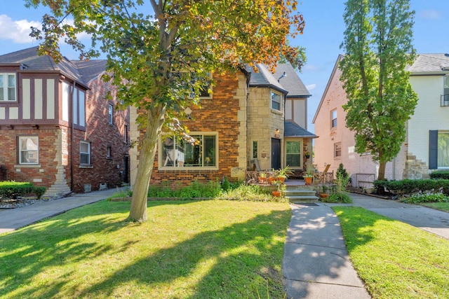 tudor-style house featuring a front lawn