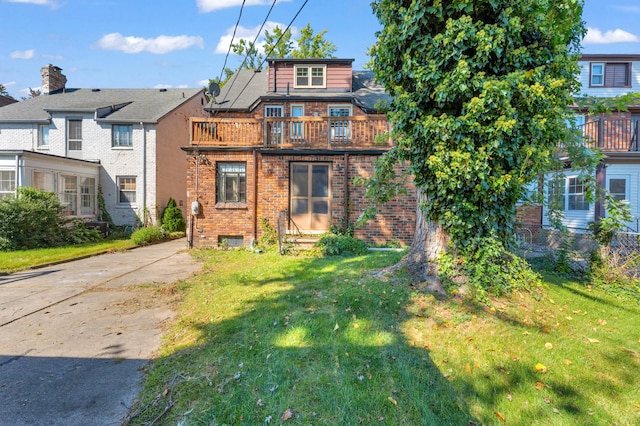 view of front of property featuring a balcony and a front yard