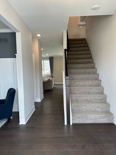 staircase with hardwood / wood-style floors