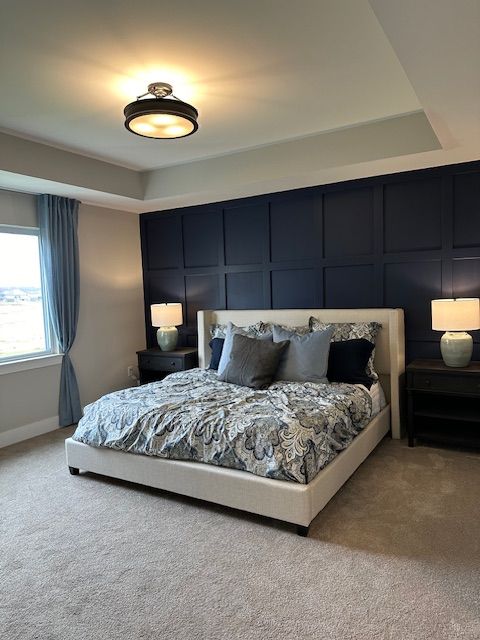 bedroom with carpet flooring and a raised ceiling