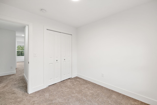 unfurnished bedroom with carpet flooring and a closet