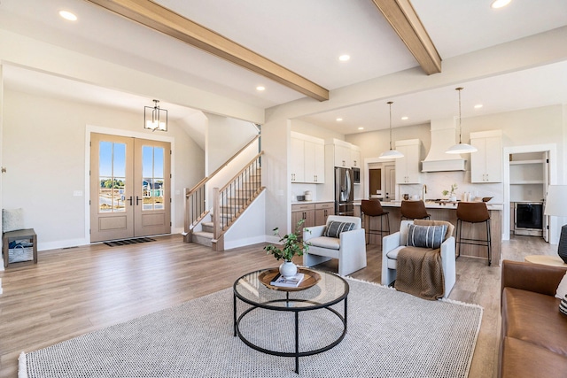 living room featuring beam ceiling, french doors, wine cooler, and light hardwood / wood-style flooring