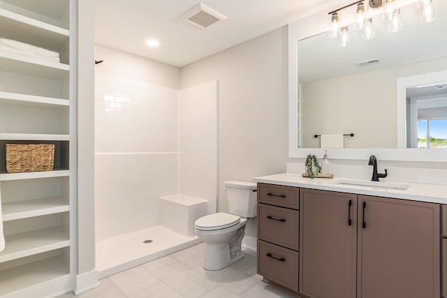 bathroom featuring tile patterned floors, vanity, toilet, and tiled shower