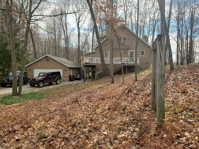 view of side of property featuring a wooden deck, an outdoor structure, and a garage