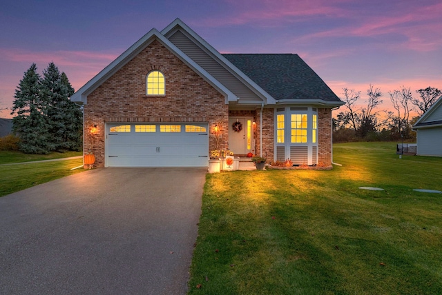 front facade featuring a garage and a lawn