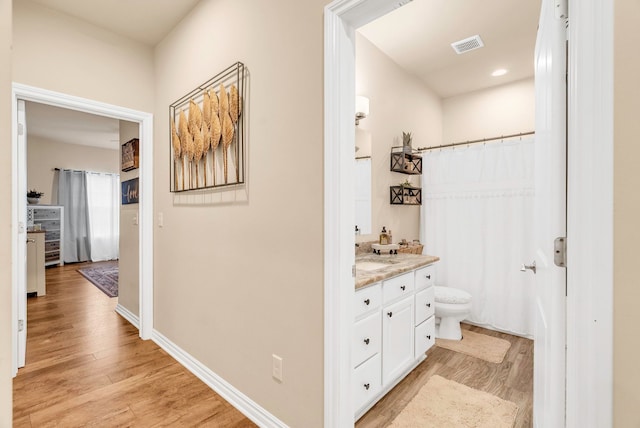 bathroom featuring hardwood / wood-style floors, vanity, and toilet