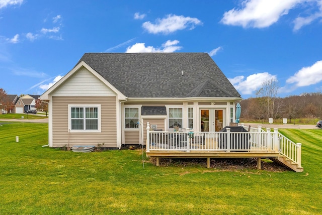 back of property with a deck and a yard