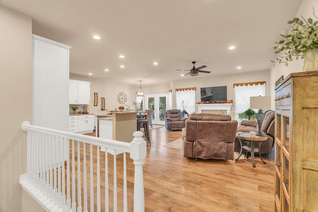 living room featuring light hardwood / wood-style flooring and ceiling fan