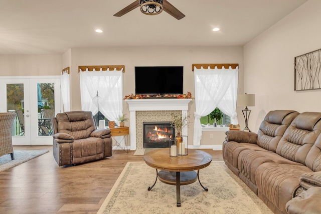 living room featuring ceiling fan, french doors, a healthy amount of sunlight, and light wood-type flooring