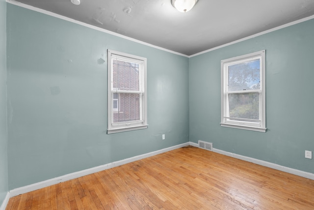 empty room with light hardwood / wood-style floors and ornamental molding