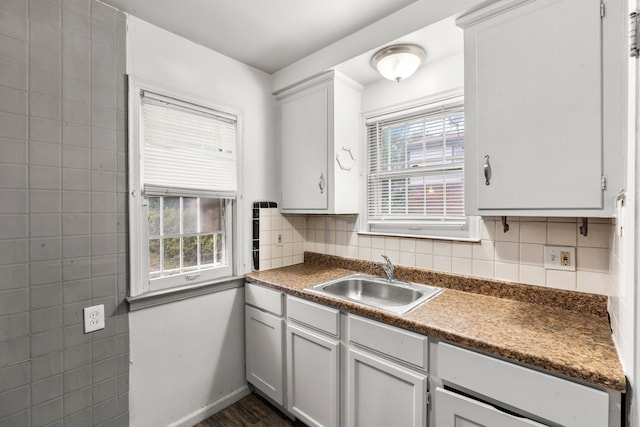 kitchen featuring decorative backsplash, dark hardwood / wood-style flooring, white cabinetry, and sink