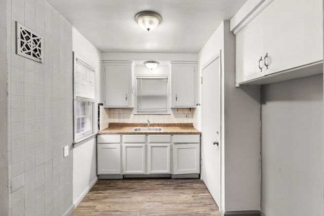 kitchen featuring backsplash, sink, white cabinets, and dark hardwood / wood-style floors