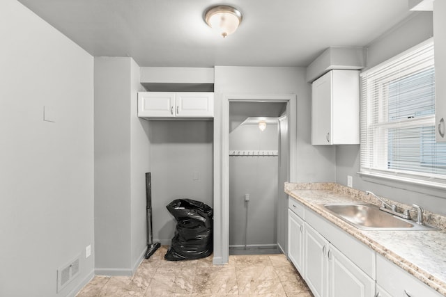 kitchen with white cabinets, plenty of natural light, and sink