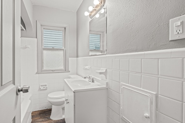 bathroom with vanity, hardwood / wood-style flooring, toilet, and tile walls