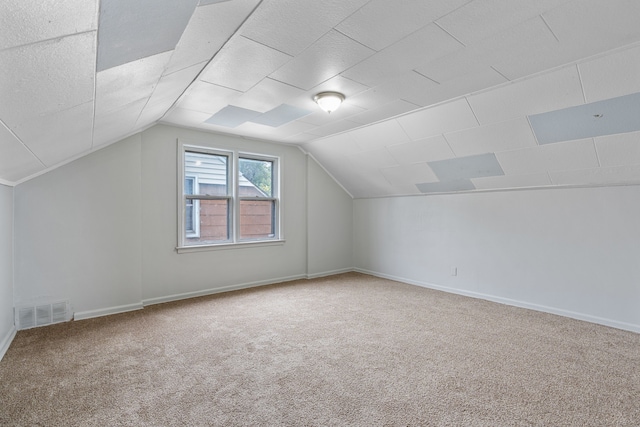 additional living space with carpet flooring and vaulted ceiling