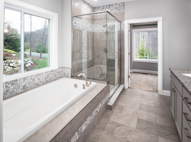 bathroom with vanity, separate shower and tub, and a wealth of natural light