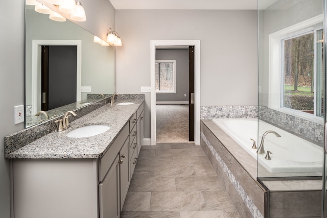 bathroom with vanity and tiled bath