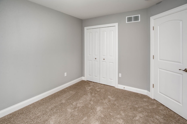 unfurnished bedroom featuring carpet flooring and a closet