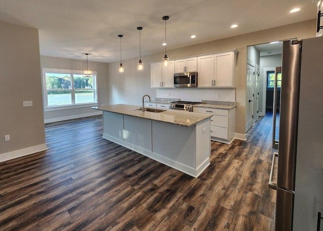 kitchen with sink, dark hardwood / wood-style flooring, an island with sink, white cabinets, and appliances with stainless steel finishes