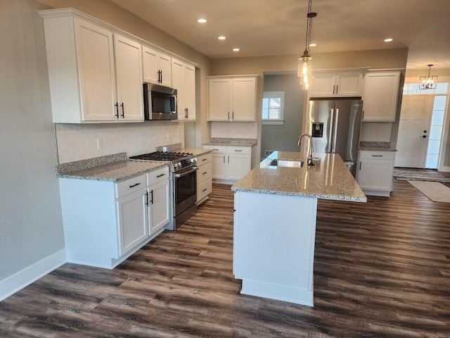 kitchen featuring white cabinetry, sink, stainless steel appliances, and decorative light fixtures