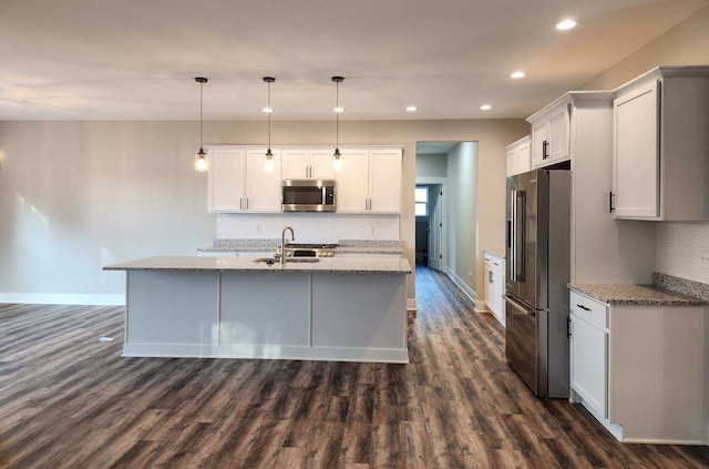 kitchen featuring light stone countertops, dark hardwood / wood-style flooring, decorative light fixtures, white cabinets, and appliances with stainless steel finishes