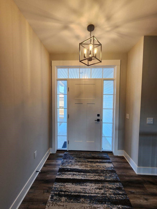 entrance foyer featuring dark hardwood / wood-style flooring and a notable chandelier