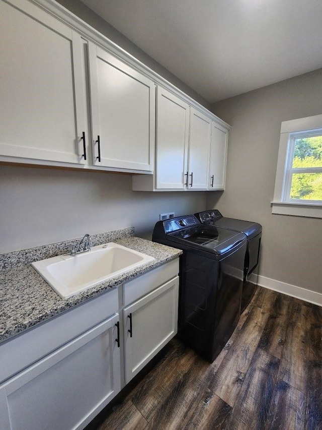 clothes washing area with cabinets, dark hardwood / wood-style flooring, separate washer and dryer, and sink