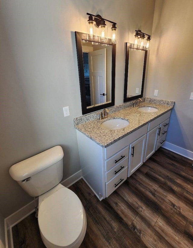 bathroom with hardwood / wood-style flooring, vanity, and toilet