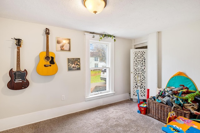 recreation room with a textured ceiling and carpet floors