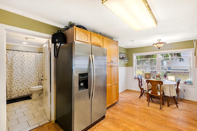 kitchen featuring stainless steel refrigerator with ice dispenser, light hardwood / wood-style flooring, and crown molding