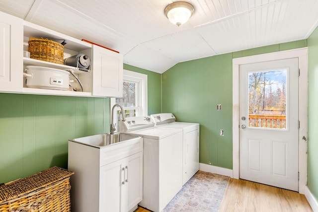 washroom with washer and dryer, light hardwood / wood-style flooring, a wealth of natural light, and cabinets