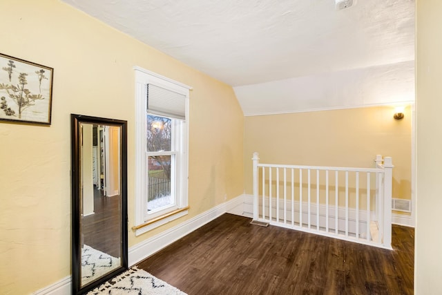 bonus room with hardwood / wood-style floors and vaulted ceiling