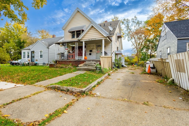 bungalow featuring a porch and a front lawn