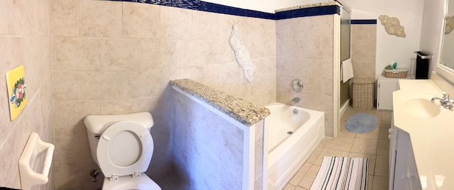 bathroom with tile patterned floors, vanity, tile walls, toilet, and a tub