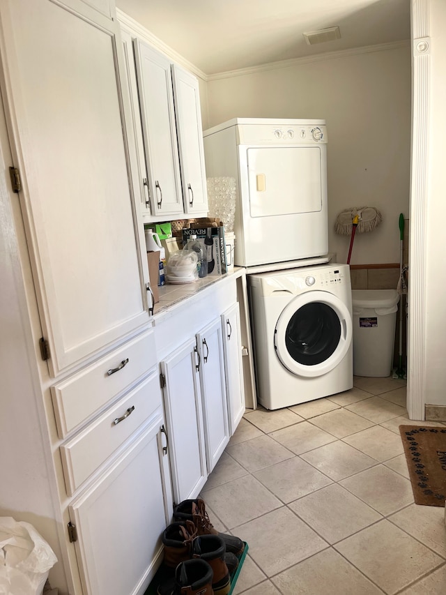 laundry room with stacked washing maching and dryer, crown molding, and light tile patterned flooring