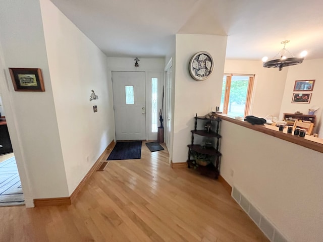 entryway featuring a chandelier and light hardwood / wood-style flooring