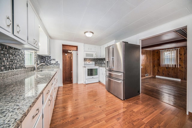 kitchen featuring light wood-type flooring, decorative backsplash, white appliances, and white cabinets