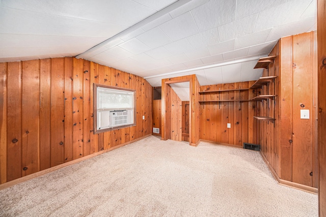 additional living space with wooden walls, cooling unit, light colored carpet, and vaulted ceiling