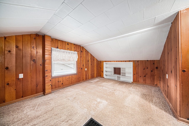 bonus room with wood walls, built in features, carpet floors, and vaulted ceiling