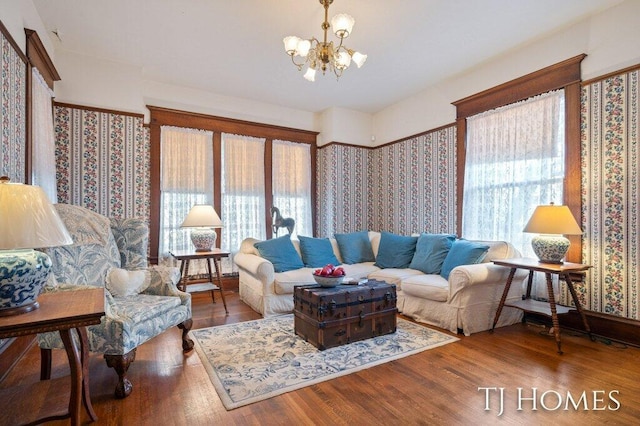 living room with hardwood / wood-style floors, a notable chandelier, and a healthy amount of sunlight