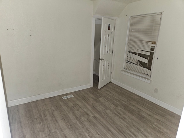 unfurnished room with wood-type flooring and lofted ceiling