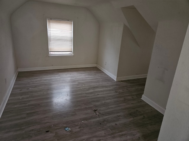 bonus room with dark wood-type flooring and vaulted ceiling