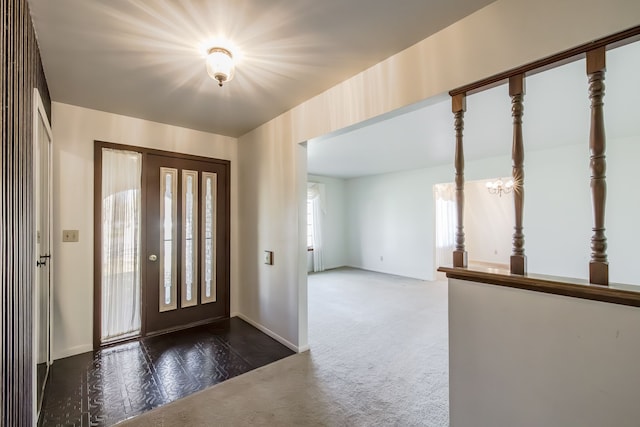 carpeted foyer featuring an inviting chandelier