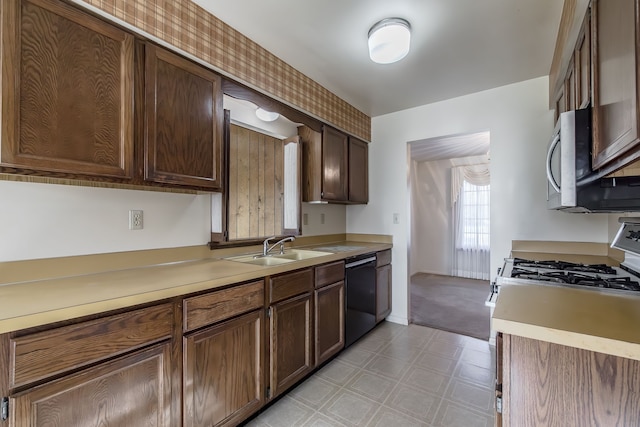 kitchen with dark brown cabinets, black dishwasher, white gas range oven, and sink