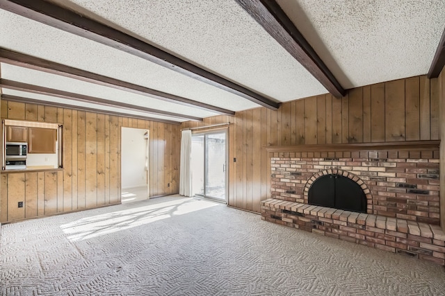 unfurnished living room featuring beamed ceiling, carpet floors, and wooden walls